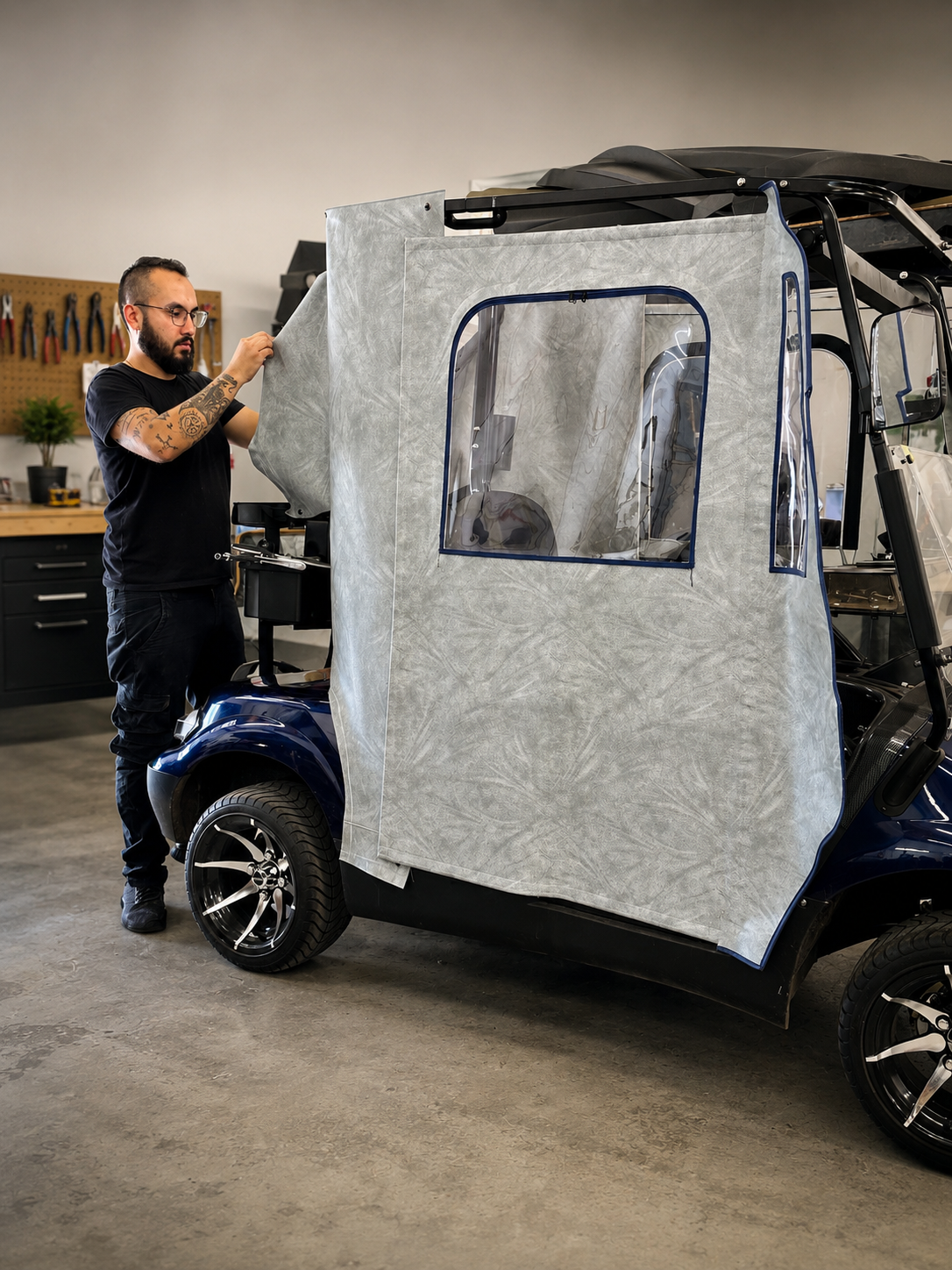 Technician installing a golf cart enclosure in the workshop